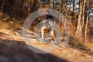 The concept of sport and healthy lifestyle. A young slender man in sports clothes is engaged in running uphill in the autumn