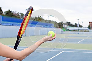The concept of sport and outdoor activities. A game with a big tennis - a hand with a ball and a racket.