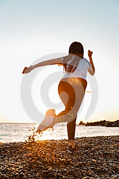 The concept of sport and running. A woman in sportswear starts for a run. Rear and bottom view. In the background, the sky and the