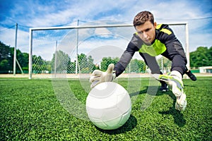 Concept sport training school, portrait man goalkeeper catches soccer ball