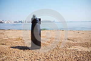 The concept of sports, ecology, tourism and outdoor activities.plastic sports reusable water bottle on the sand on the beach