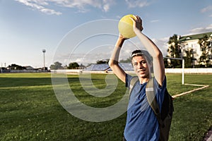 Concept of sports and health - teen boy posing at a stadium, a soccer field with green grass