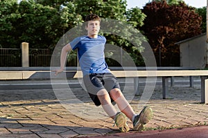 Concept of sports and health - teen boy training and pushups at the stadium. Physical exercise. Workout, fitness and health care