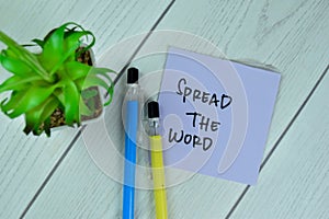 Concept of Spread the word write on sticky notes isolated on Wooden Table