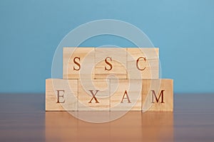 Concept of SSC exam conducted in India, in wooden block letters on table