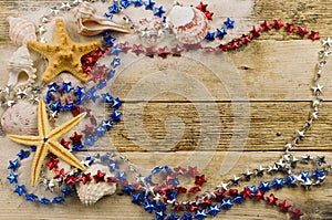 Concept for summer United States holiday of fourth of July on the beach with shells, starfish, and sand.