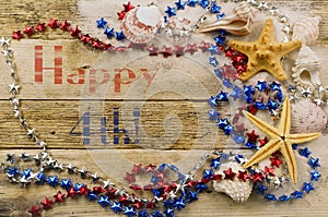 Concept for summer United States holiday of fourth of July on the beach with shells, starfish and sand with message