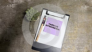 Concept of Tardive Dyskinesia write on sticky notes isolated on Wooden Table