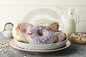 Concept of tasty food with donuts and milk on gray background