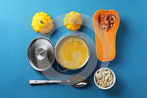 Concept of tasty food with pumpkin soup on blue background