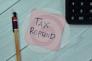 Concept of Tax Refund write on sticky notes isolated on Wooden Table
