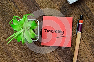 Concept of Taxonomy write on sticky notes isolated on Wooden Table