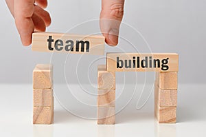 Concept of team building - hand holds a wooden block with the inscription