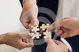 The concept of teamwork and partnership. Businessman's hands putting together puzzle pieces