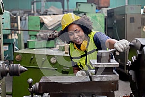 Concept of technician heavy industry, Woman African American engineer wear hardhat working at machine in factory. Female