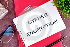 The concept of technology . The conceptual text of CYPHER ENCRYPTION in a mini notebook on a business book, close-up photo