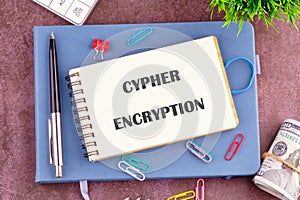 The concept of technology and development. The CYPHER ENCRYPTION concept phrase in the notebook, top view. Copy space photo