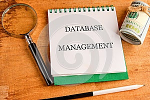 The concept of technology and development. Phrase, words, text DATABASE MANAGEMENT in a notebook on an old background