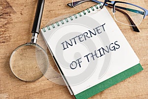 The concept of technology and development. Phrase, words, text INTERNET OF THINGS in a notebook on an old background, in