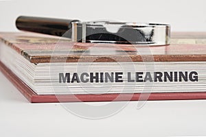 The concept of technology and development. Phrase, words, text MACHINE LEARNING on the end of the book, a close-up front