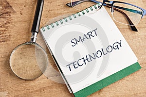 The concept of technology and development. Phrase, words, text SMART TECHNOLOGY in a notebook on an old background, in a