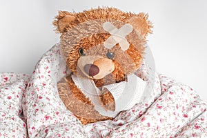 Concept teddy bear childhood diseases at textile background