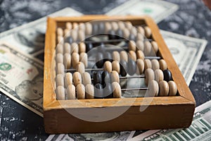 Concept on the theme of the financial crisis. Close-up Dollars on which lie wooden old abacus. Selective focus