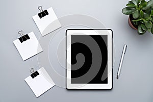 The concept of time management, completing tasks, food recipes. Digital tablet and empty pieces of paper on a gray background