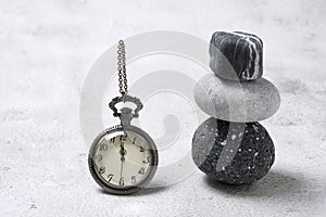 The concept of time and stones. Vintage clock with zen stones. Time management, slow life, simplify