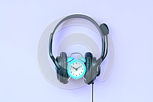 Concept of time to listening music. Alarm clock and headphones