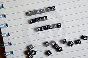 Concept of Time To Lose Weight on wooden cubes with books in background