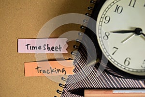 Concept of TimeSheet Tracking write on sticky notes isolated on Wooden Table