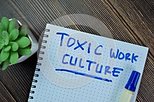 Concept of Toxic Work Culture write on book isolated on Wooden Table
