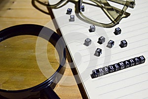 Concept of Trademarks on wooden cubes with magnifying glass, glass eye, books in Vintage background