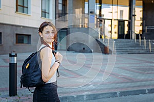 Concept of training and education. High school concept. Young beautiful cheerful student grimaces and has fun on the way