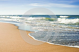 The concept of travel and rest at the seaside, sea waves on the background of the shoreline and sunset