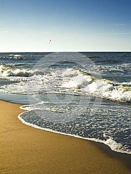 The concept of travel and rest at the seaside, sea waves on the background of the shoreline and sunset