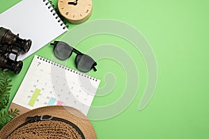 concept of travel time accessories vacation trip and long summer weekend planning on green table with blank space for