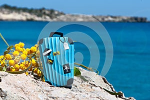 Concept travel to the sea. Stylish suitcase against the blue sea