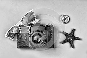 The concept: travel, vacation, active leisure, sea voyages. Ancient camera, sunglasses, old compass and starfish on a blue backgro