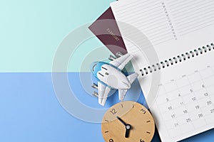 Concept of travel vacation trip and long summer weekend planning, clock, calendar, passport on blue and green table background