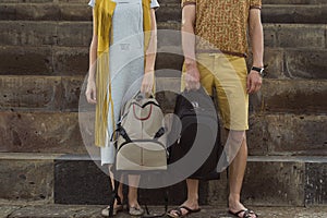 Concept traveling together, honeymoon. Stylish couple in love with backpacks standing on footstep