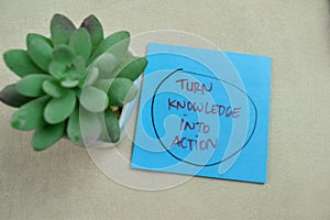 Concept of Turn Knowledge Into Action write on sticky notes isolated on Wooden Table