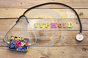 Concept typhoid, heart stethoscope and colorful letters in metal box