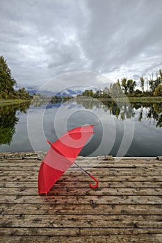 Concept of umbrella on a wooden dock