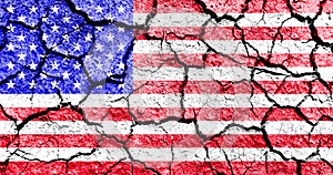 Concept of United States of America hardship times and drought with dry cracked soil and american flag