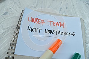 Concept of Unser Team Sucht Verstarkung write on sticky notes isolated on Wooden Table photo