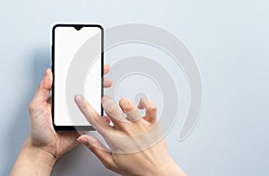 Concept of use of the smartphone. A smartphone with a white blank screen in the hand of a woman