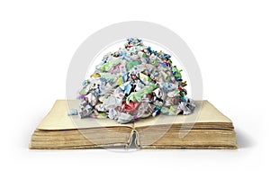 The concept of useless knowledge. Garbage pile on open book photo