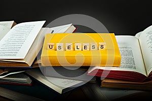 The concept of useless knowledge. Useless - word from wooden blocks